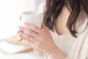おなかの冷えと自律神経の関係を整えるために温かい飲み物を飲む女性