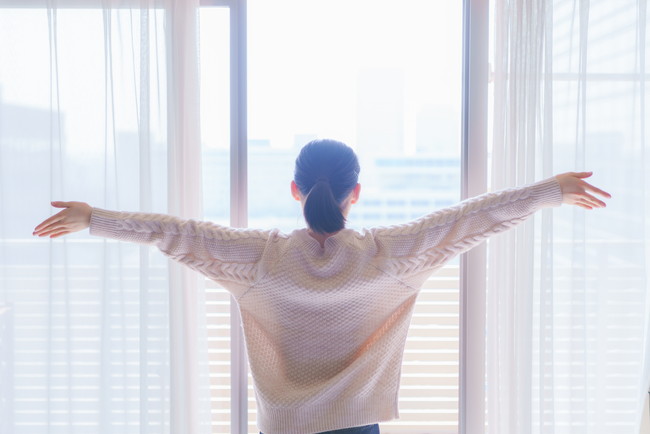 朝の光を浴びて深呼吸する女性|自律神経を整える朝の習慣