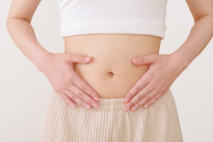 お腹に手を当てて深呼吸している女性