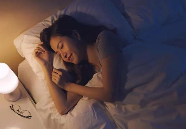 眠れない夜にベッドで静かに過ごす女性のイメージ（春の不眠・自律神経のゆらぎ）